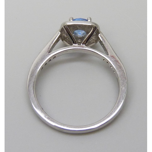 7056 - A platinum ring set with a Swarovski blue natural topaz surrounded with brilliant cut diamonds and d... 