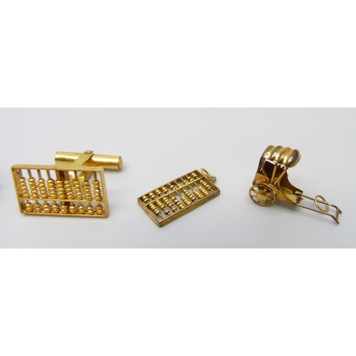 7063 - Three 14ct gold charms and a single cufflink, 6.8g