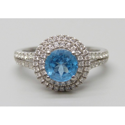 7068 - A platinum ring with a Swarovski blue natural topaz surrounded with brilliant cut diamonds and diamo... 