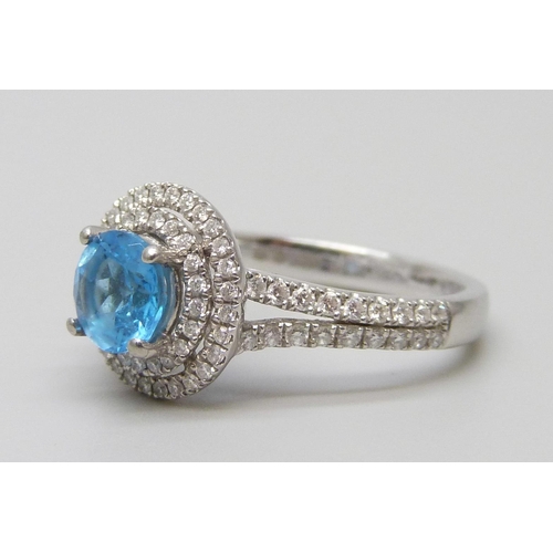 7068 - A platinum ring with a Swarovski blue natural topaz surrounded with brilliant cut diamonds and diamo... 