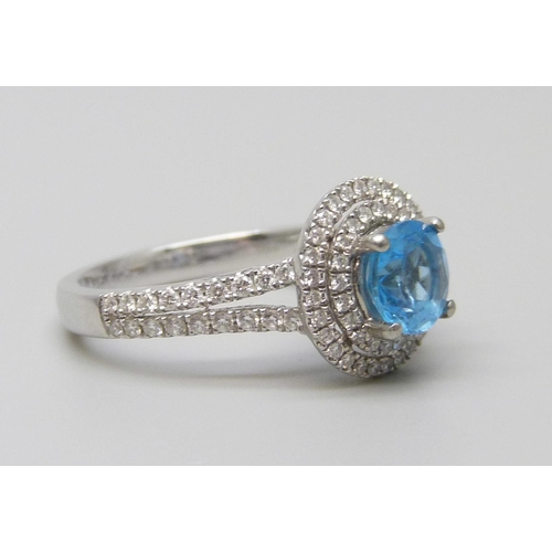 7068 - A platinum ring with a Swarovski blue natural topaz surrounded with brilliant cut diamonds and diamo... 