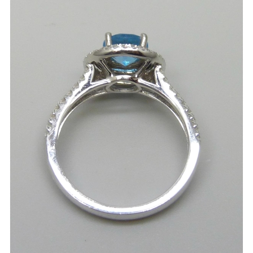 7068 - A platinum ring with a Swarovski blue natural topaz surrounded with brilliant cut diamonds and diamo... 