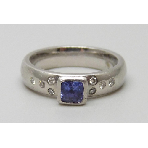 7074 - A handmade platinum ring set with a square tanzanite and diamond shoulders, 8.9g, K