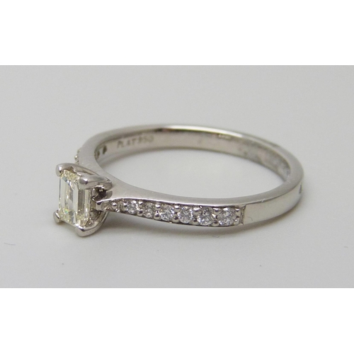 7089 - A platinum and emerald cut diamond ring with diamond set shoulders, total diamond weight 0.55ct, 3.4... 