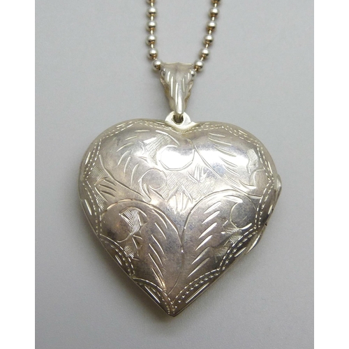 7140 - A large silver heart shaped locket and chain