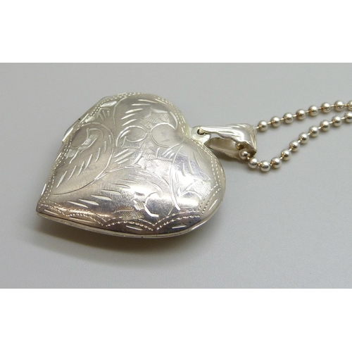 7140 - A large silver heart shaped locket and chain