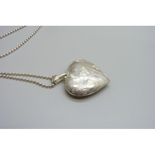 7140 - A large silver heart shaped locket and chain