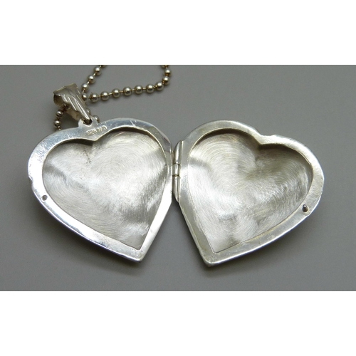 7140 - A large silver heart shaped locket and chain