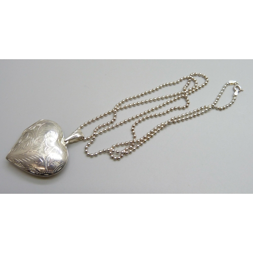 7140 - A large silver heart shaped locket and chain