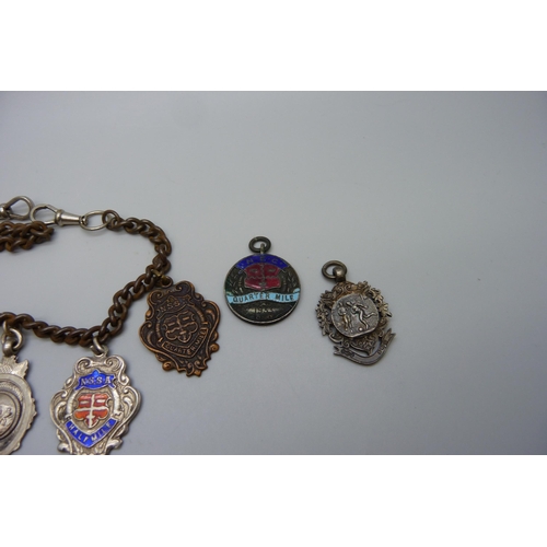 7151 - Five silver fob medals including one football, one tug-of-war and one enamelled, two other medallion... 