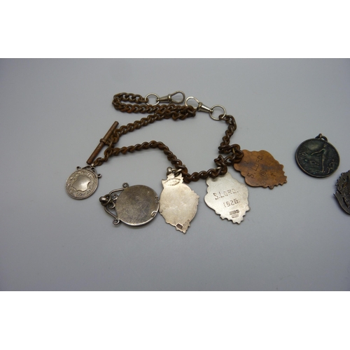 7151 - Five silver fob medals including one football, one tug-of-war and one enamelled, two other medallion... 