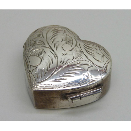 7152 - A heart shaped silver pill box with engraved decoration