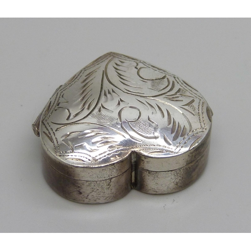 7152 - A heart shaped silver pill box with engraved decoration