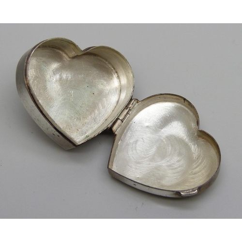 7152 - A heart shaped silver pill box with engraved decoration