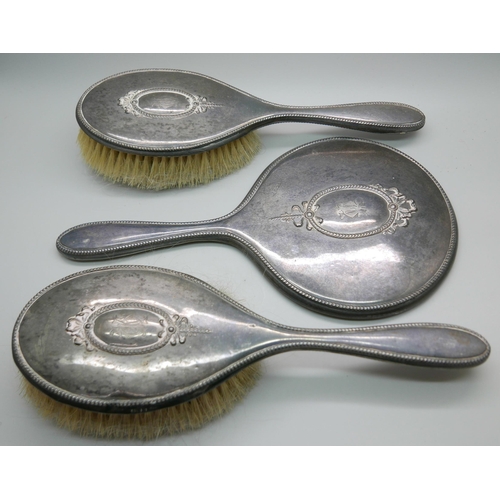 7336 - Two silver back brushes and a hand mirror by Walker & Hall