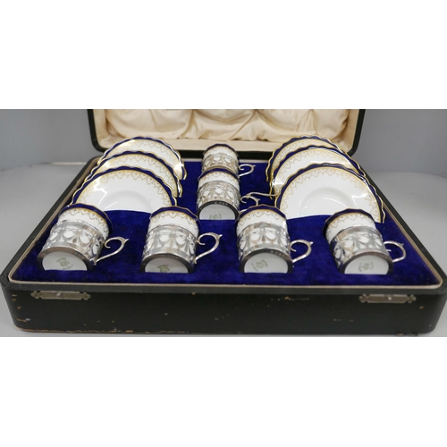 7338 - A cased set of six Aynsley coffee cans and saucers with silver holders, 108g of silver, (two cans an... 