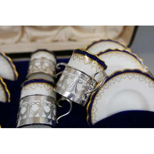 7338 - A cased set of six Aynsley coffee cans and saucers with silver holders, 108g of silver, (two cans an... 