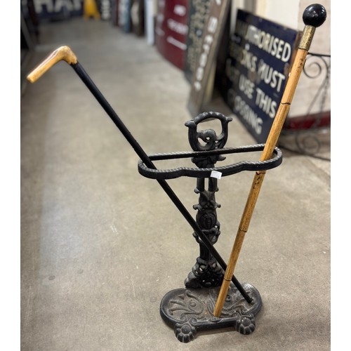 243 - A Victorian style cast metal stickstand with two walking sticks