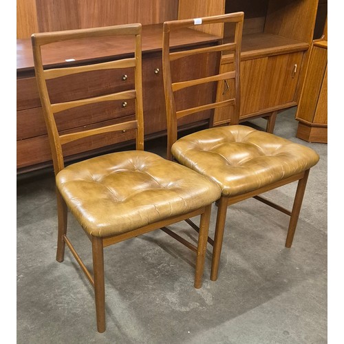 106 - A pair of teak and tan leather dining chairs