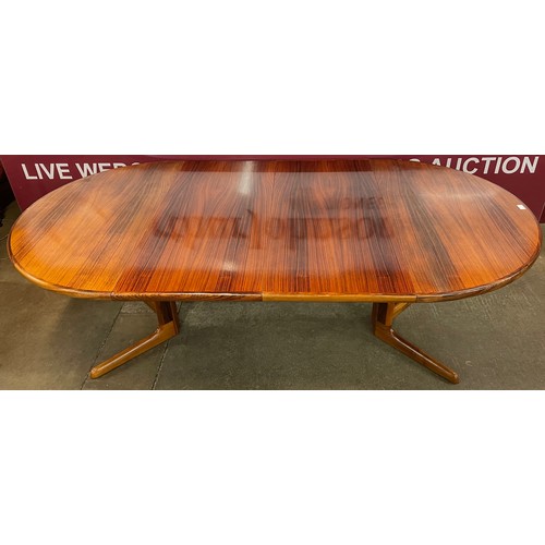 60 - A Danish simulated rosewood circular extending dining table