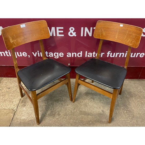 92 - A pair of teak and black vinyl chairs