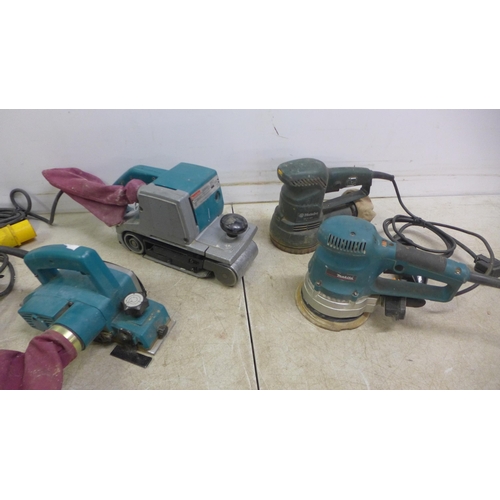 5031 - Four 110v power tools including Makita 9401 belt sander, a Makita electric planer, a Makita BO6030 o... 