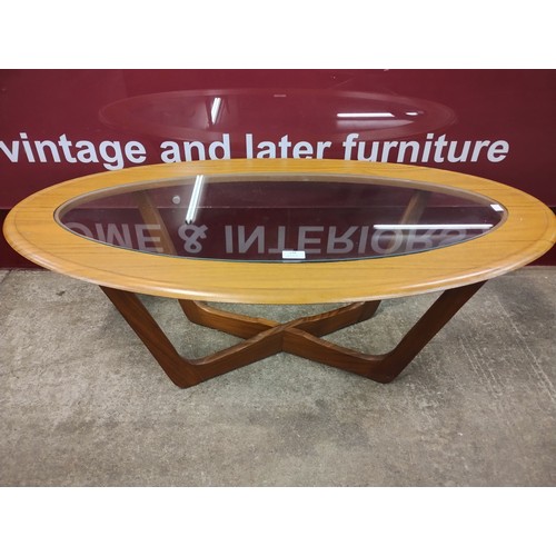 128 - A teak and glass topped oval coffee table