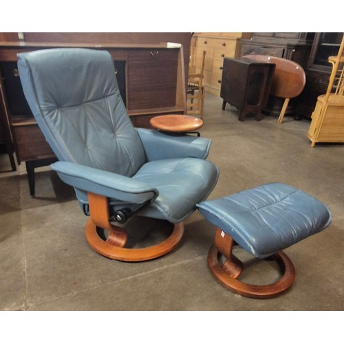 115 - A Norwegian Ekornes beech and blue leather revolving Stressless lounge chair and ottoman