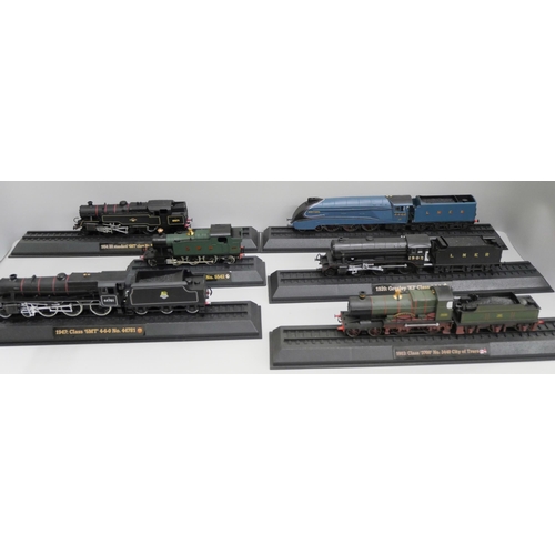 2104 - A box of plastic model rail locomotives on plinths