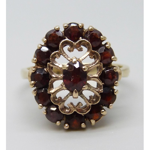 7003 - A yellow metal and garnet cocktail ring, 5.4g, T