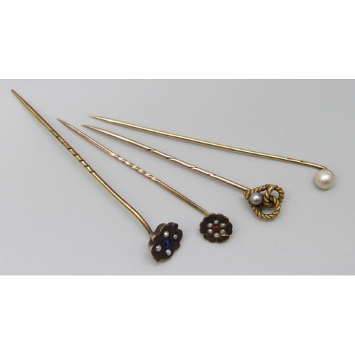 7004 - A 15ct gold stick pin with rope twist detail, 1.2g, a 9ct gold stick pin and two others