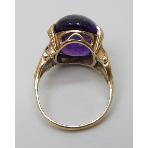 7005 - A 9ct gold ring set with a purple cabochon stone, 4.8g, L