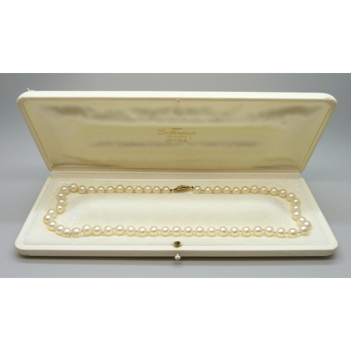 7017 - A string of cultured pearls with a 9ct gold clasp