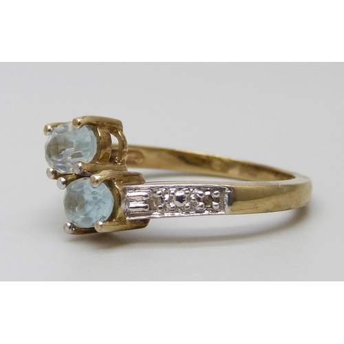 7036 - A 9ct gold, aquamarine and diamond crossover ring, 3.5g, P