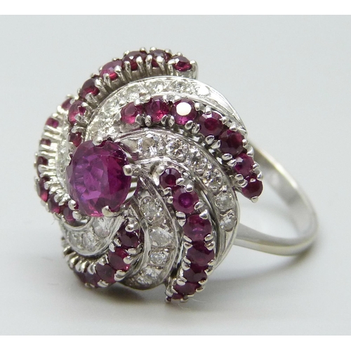 7047 - A large ruby and diamond cocktail cluster ring, white metal tests as 18ct gold, rubies 1.40 carat es... 