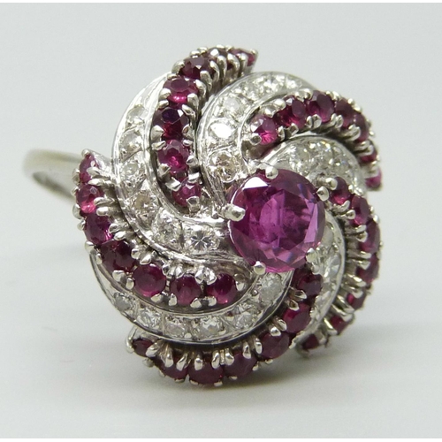 7047 - A large ruby and diamond cocktail cluster ring, white metal tests as 18ct gold, rubies 1.40 carat es... 