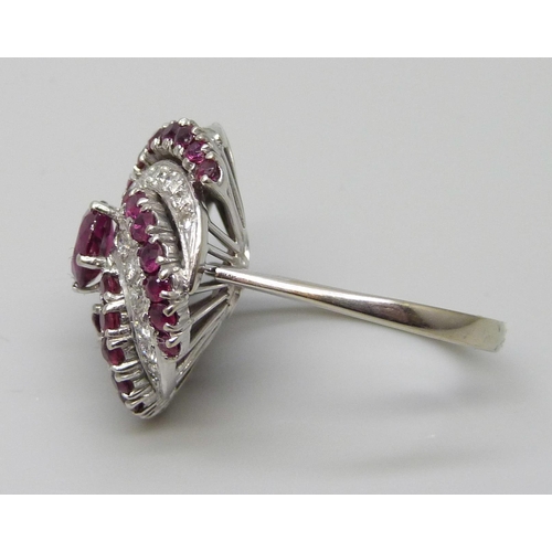 7047 - A large ruby and diamond cocktail cluster ring, white metal tests as 18ct gold, rubies 1.40 carat es... 