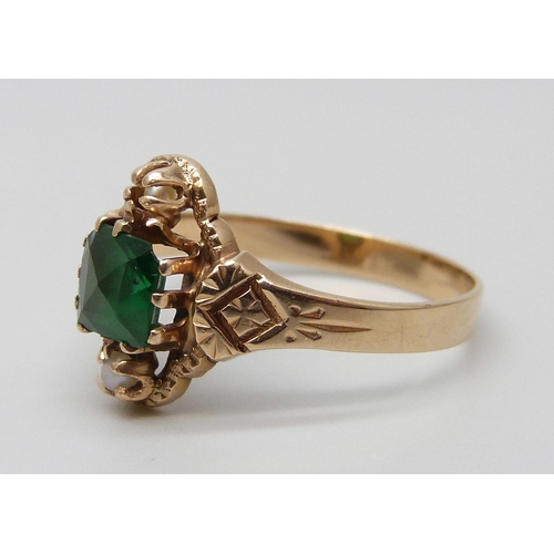 7062 - An Edwardian yellow metal ring set with a green stone and two seed pearls, 2.1g, N, tests as 14ct go... 