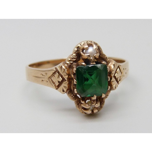 7062 - An Edwardian yellow metal ring set with a green stone and two seed pearls, 2.1g, N, tests as 14ct go... 