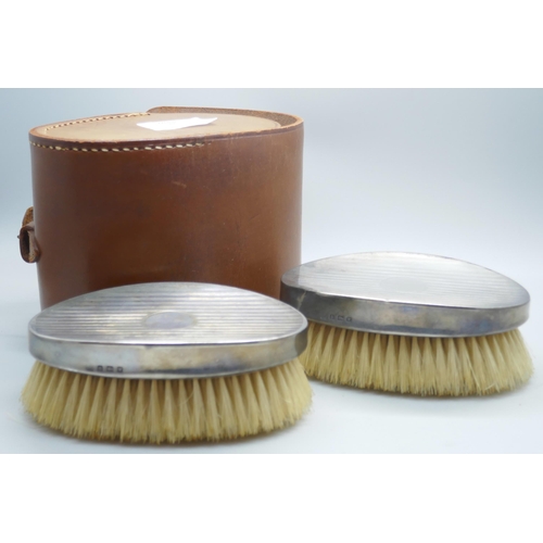 7281 - A pair of silver brushes in a fitted leather case, circa 1940s