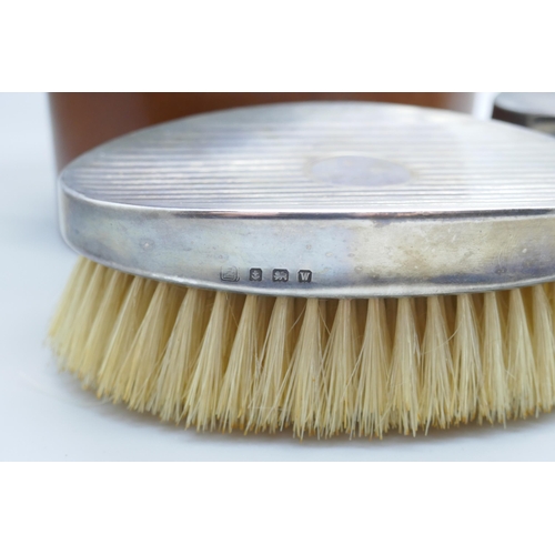 7281 - A pair of silver brushes in a fitted leather case, circa 1940s