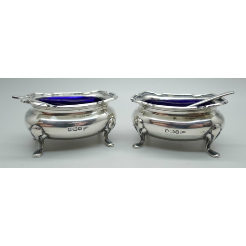 7292 - A pair of silver salts with blue glass liners and silver spoons, Walker & Hall, Sheffield 1908, 63g