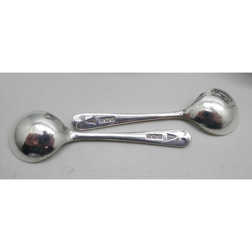 7292 - A pair of silver salts with blue glass liners and silver spoons, Walker & Hall, Sheffield 1908, 63g