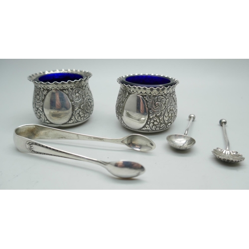 7295 - A pair of crested silver salts with blue glass liners, together with two salt spoons, (not matching)... 