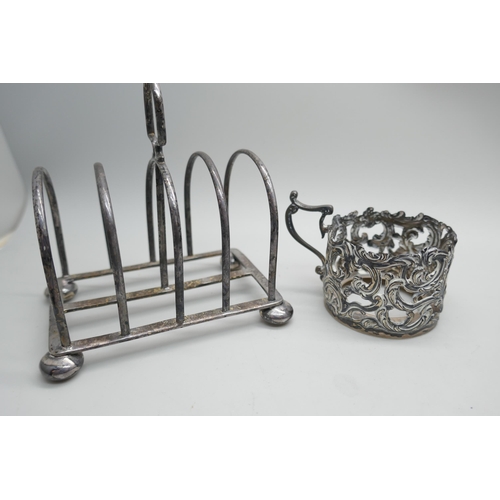 7296 - A collection of silver; cup holder, toast rack, mustard and salt spoon, 146g, a letter opener, tongs... 