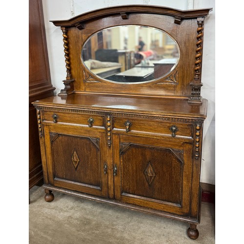 195 - An early 20th Century carved oak mirrorback sideboard