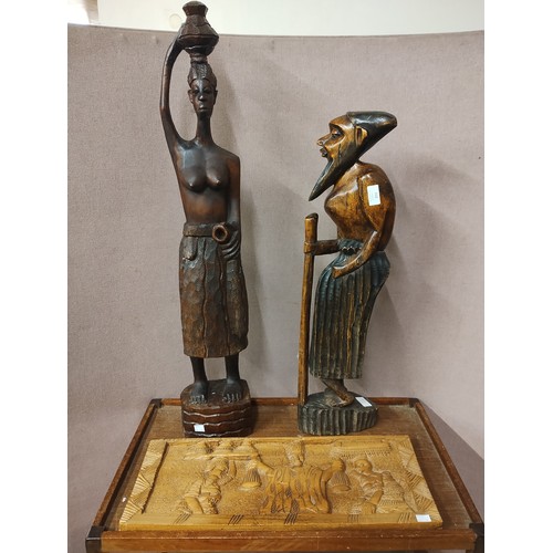 416 - Two African carved wooden figures and a plaque