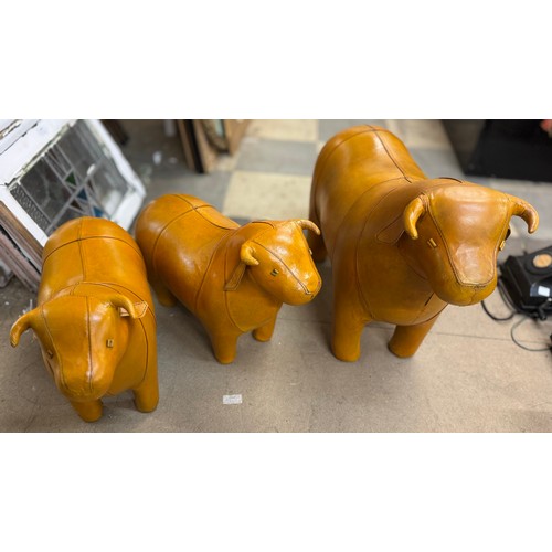 403 - A set of three Liberty & Co. style butterscotch leather bull footstools