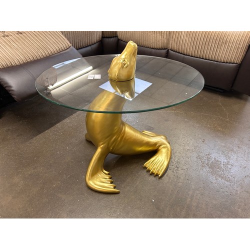 3002 - A glass topped and gold painted occasional table in the form of a seal