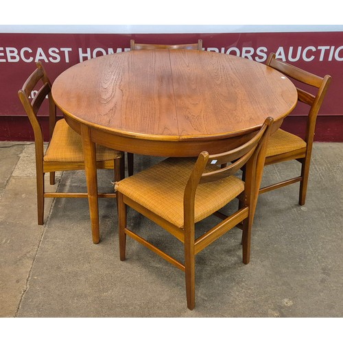 19 - A teak circular extending dining table and four chairs